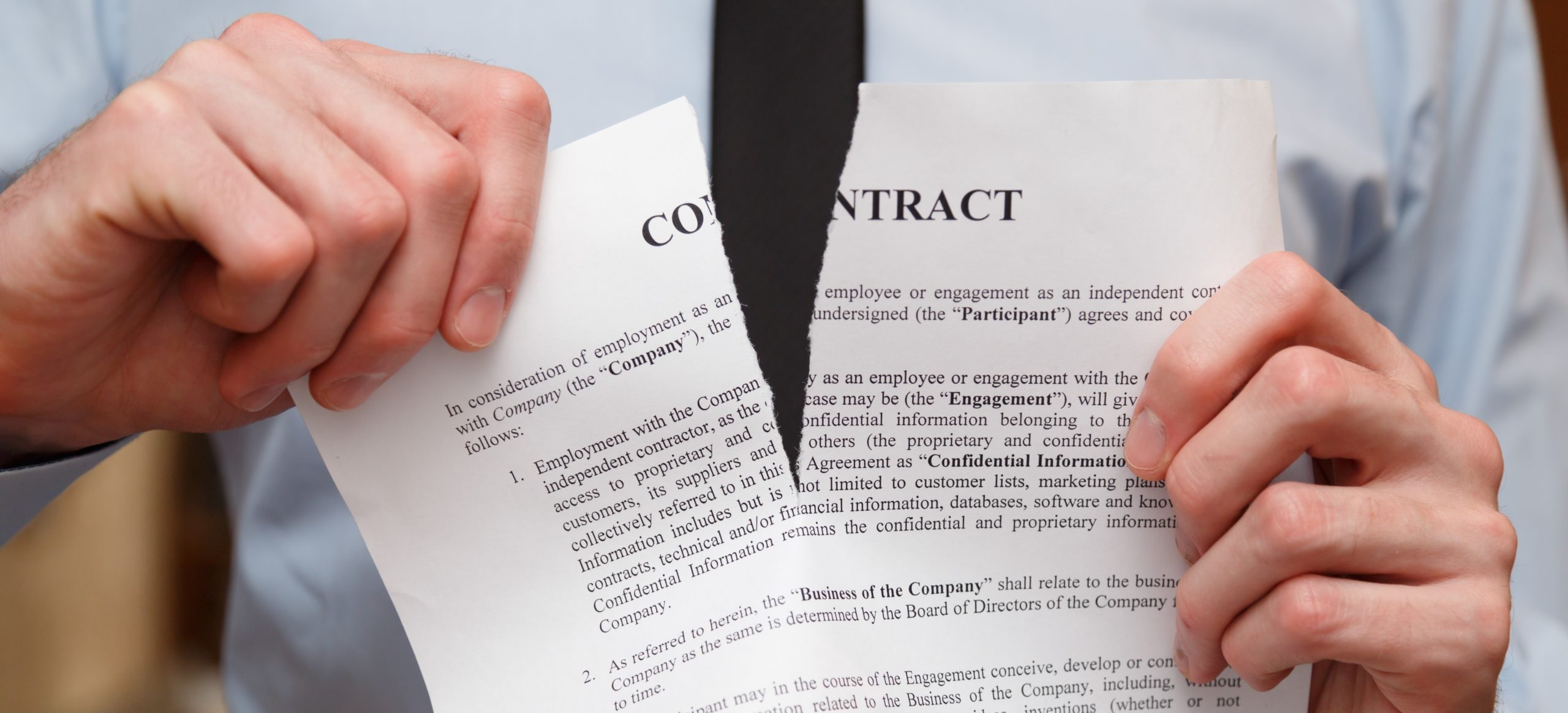 Man tearing contract in half