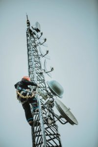 Radio technician climbing antenna tower